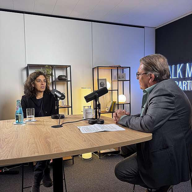 Dr. Andreas Bartels und Dr. Susanne Filfil sitzend am Hochtisch im Studio