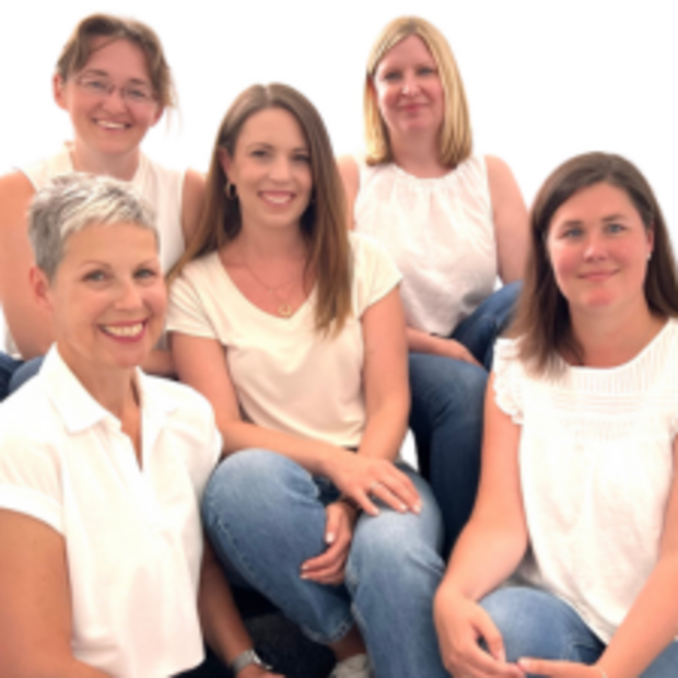 Fünf Frauen des Weiterbildung-Beraterteams lächeln in die Kamera.